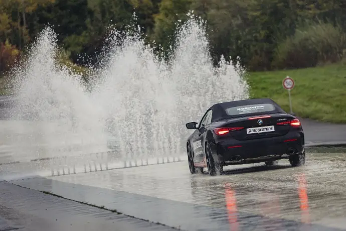 Fahrzeug vor Wasserhinderniss im ADAC Training Fahrzeug auf nasser Fahrbahn im ADAC-Kompakttarining